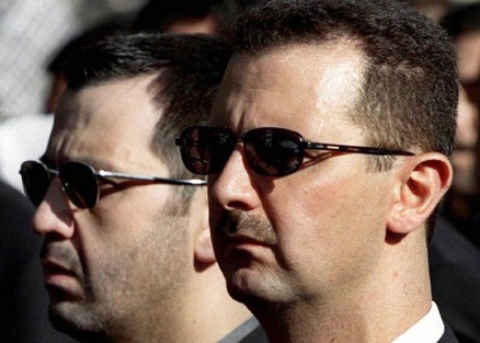 O ex-ditador da Sria, Bashar Al-Assad, e ao fundo seu irmo