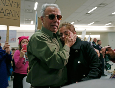 A iraniana Shima Behgooy, que tem o Green Card, chora nos ombros de seu sogro Ahmad Behgooy, depois de ser liberada no aeroporto de Dallas Fort Worth, no Texas. Incialmente, ela tinha sido barrada ao chegar aos EUA 