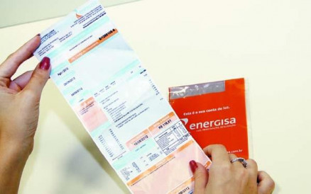 Pessoa com conta de energia nas mos; economia pode chegar a 20%