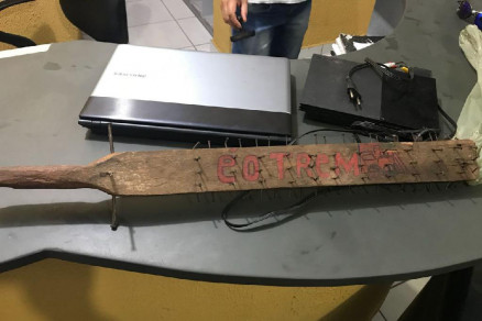 Vrios materiais sem identificao estavam na residncia, como um basto de madeira com pregos com escrita usada por faces criminosas
