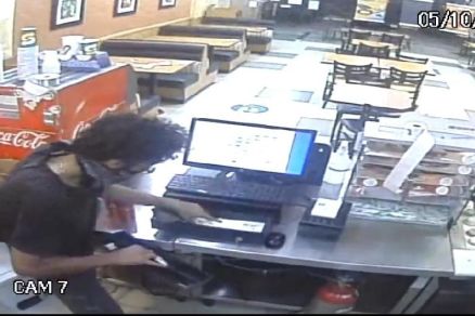 Momento em que assaltante pega o dinheiro do caixa