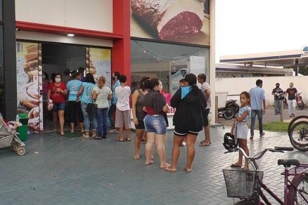 Filha em frente a aougue para receber doao de ossinhos