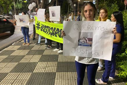 Juliane, tutora de Charlote, com cartaz em protesto em frente  veterinria e Pet Shop Bendita Pata