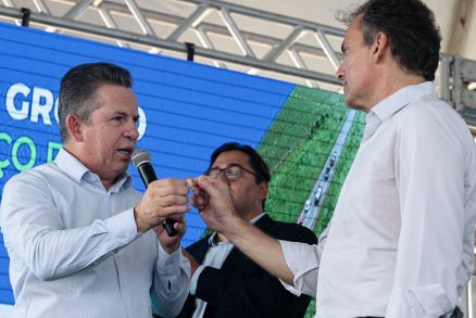 O momento em que o governador Mauro Mendes entrega a moeda a Julio Perdigo