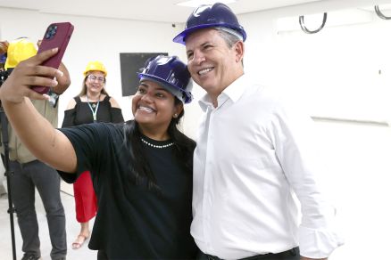 O governador Mauro Mendes posa com simpatizante durante visita a obra de hospital