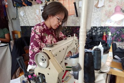 Maria da Aparecida costurando pe�a de cliente em seu ateli�