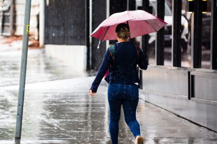 Pedestre caminha em dia de chuva em Cuiab e calor deve chegar a 36C