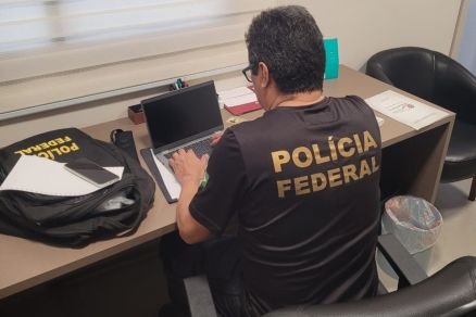 Policial federal analisa computador em um dos endereos alvos da operao 