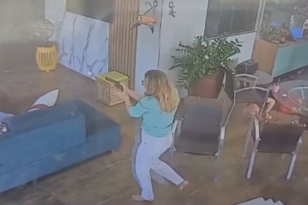 A pecuarista In�s Gemilaki aponta a arma dentro da resid�ncia invadida