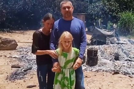 A fam�lia do produtor Daniel Klitzke e a casa destru�da ao fundo