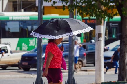 Pessoas se protegendo do sol no centro de Cuiab 