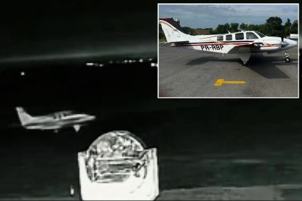 Imagem mostra momento em que avio bimotor (em detalhe)  levado de hangar 