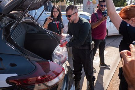 Policiais chegam a delegacia com material apreendido na operao