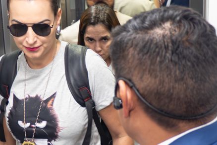 Ao fundo, Aline Valandro Kounz, presa por suspeita de envolvimento na morte de personal 