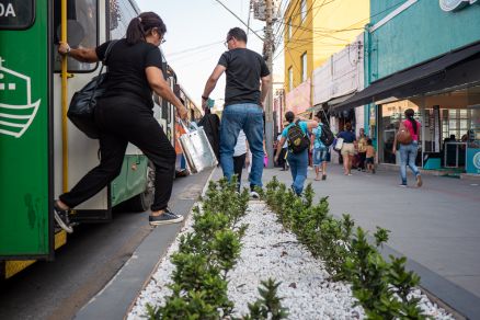 Pessoas precisam passar por cima de floreiras para descerem do nibus 