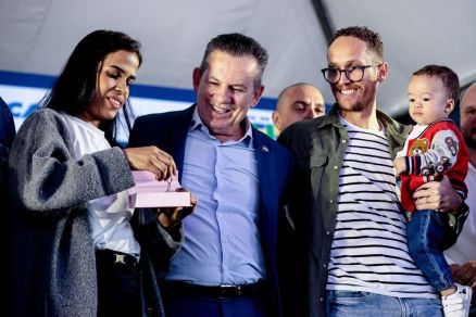 O governador Mauro Mendes, ao lado de casal que recebeu a casa