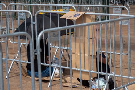 Fs usando papelo para se protegerem do sol na Arena Pantanal 