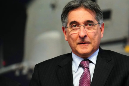 Homem de terno escuro e camisa branca sentado  mesa de jantar, com as mos entrelaadas e expresso atenta. Ao fundo, parede de pedra e arranjo floral vermelho. O ex-governador de Minas Gerais Fernando Pimentel