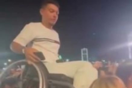 Amigos levantando cadeirante durante o show