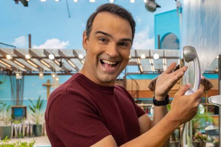 Tadeu Schmidt posa junto ao Big Fone na casa do BBB 25